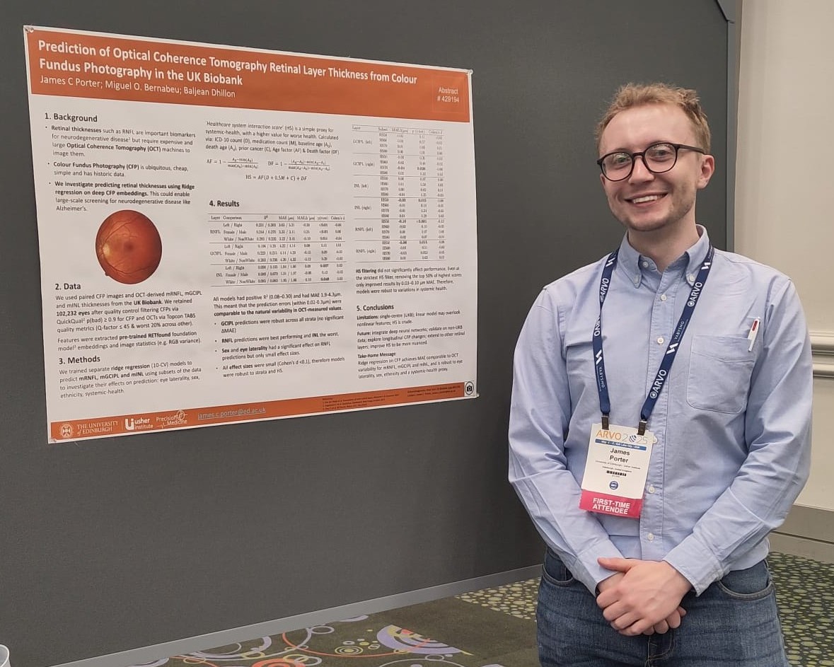 James Porter, a white male wearing a blue shirt, jeans and glasses, standing next to his poster presentation