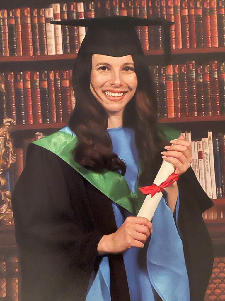 A newly-qualified optometrist holds a graduation scroll.